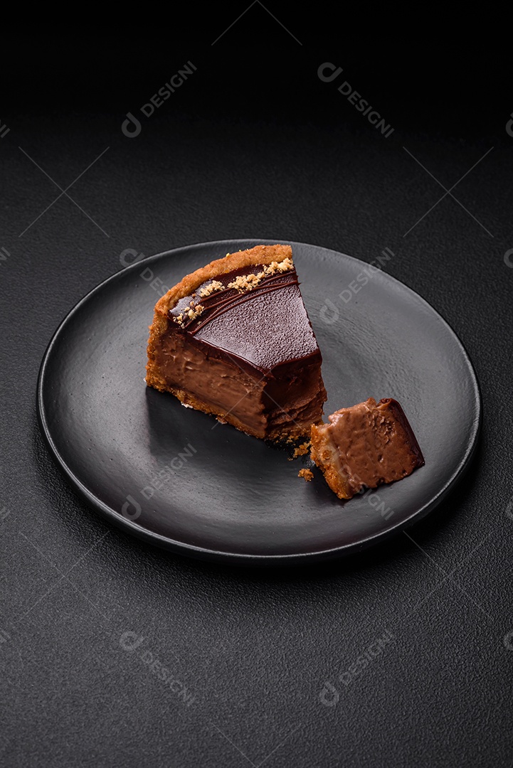 Rolo de merengue delicioso, fresco e doce com creme, lascas de amêndoa, nozes e frutas cortadas em fatias sobre um fundo escuro de concreto