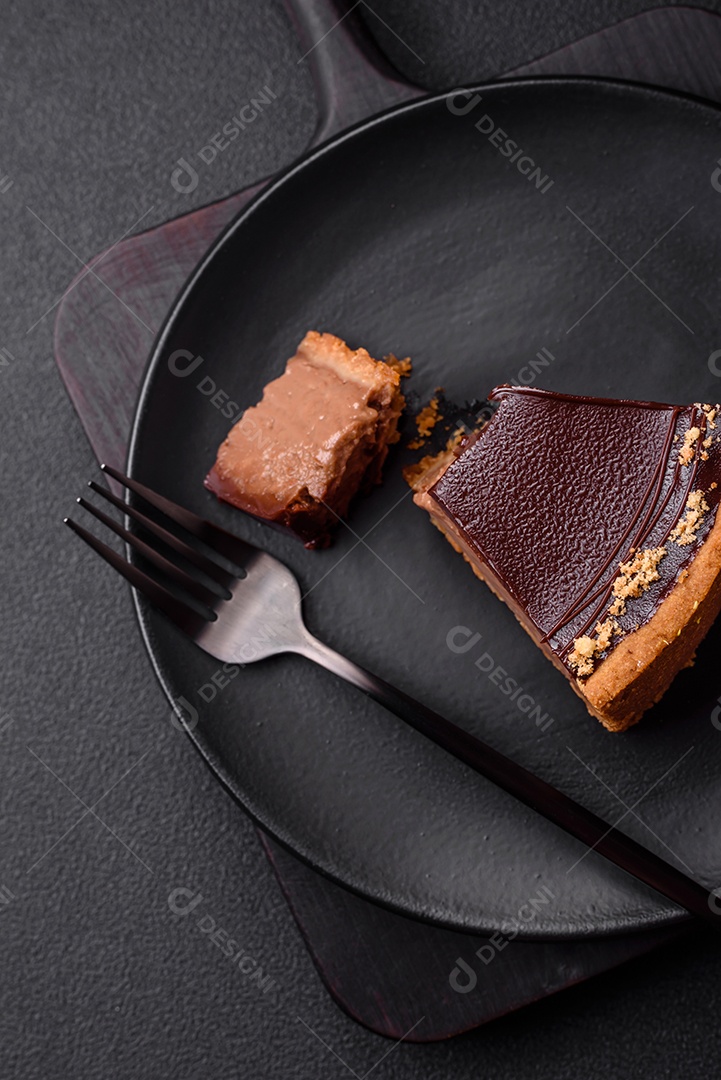 Rolo de merengue delicioso, fresco e doce com creme, lascas de amêndoa, nozes e frutas cortadas em fatias sobre um fundo escuro de concreto