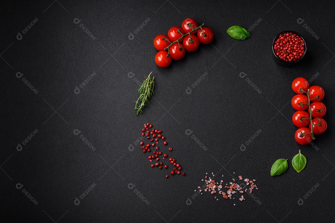 Deliciosos tomates cereja frescos nos galhos como ingrediente para cozinhar um prato vegetariano sobre um fundo escuro de concreto