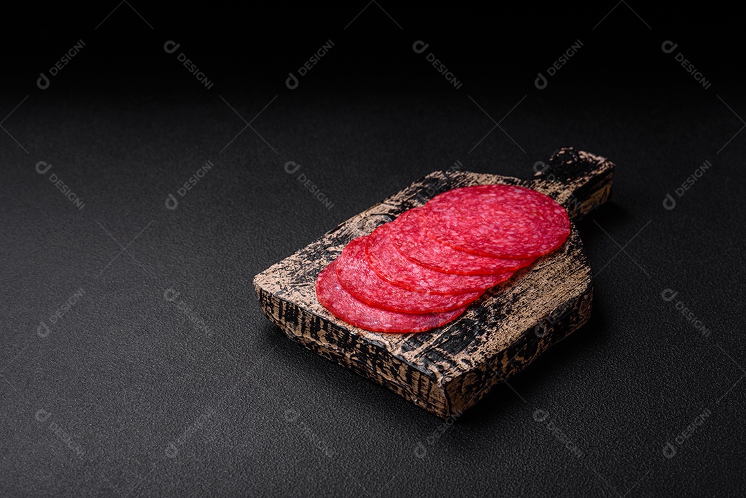 Deliciosas almôndegas frescas e massas em molho de tomate com sal, especiarias e ervas sobre um fundo escuro de concreto