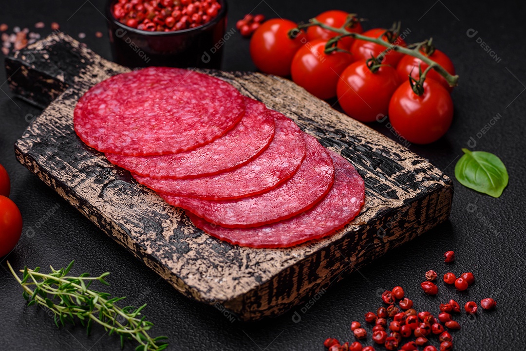 Deliciosas almôndegas frescas e massas em molho de tomate com sal, especiarias e ervas sobre um fundo escuro de concreto