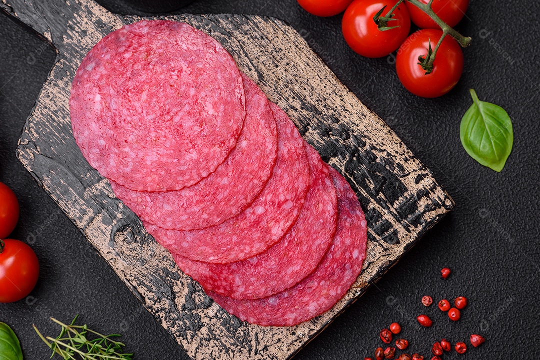 Deliciosas almôndegas frescas e massas em molho de tomate com sal, especiarias e ervas sobre um fundo escuro de concreto