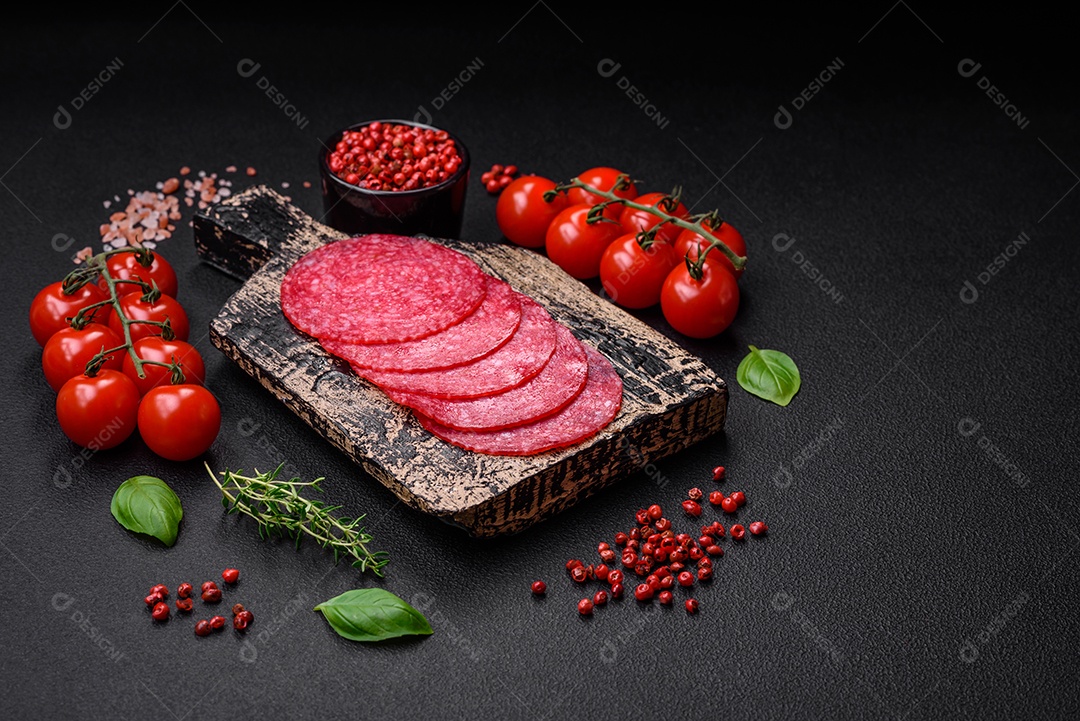 Deliciosas almôndegas frescas e massas em molho de tomate com sal, especiarias e ervas sobre um fundo escuro de concreto