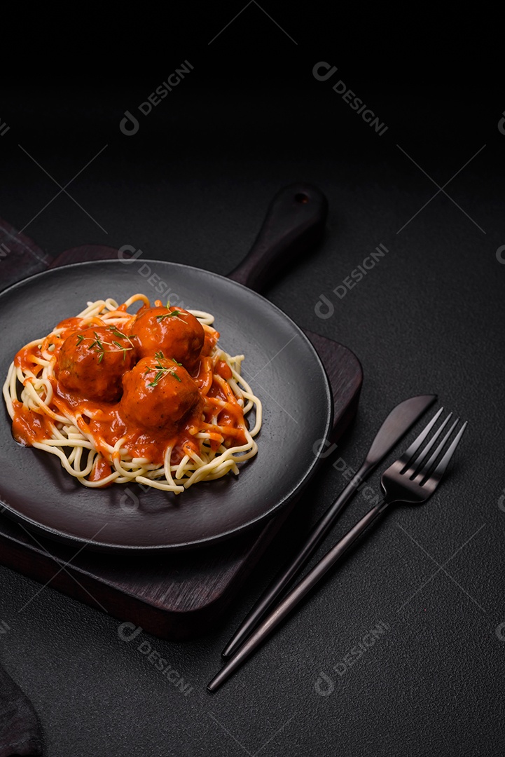 Deliciosa massa fresca com cogumelos champignon em molho cremoso com sal, especiarias e ervas sobre fundo escuro de concreto