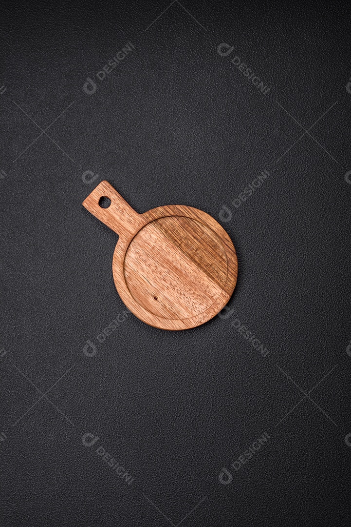 Tábua de corte de madeira de cozinha redonda vazia na cor marrom sobre um fundo de concreto texturizado escuro