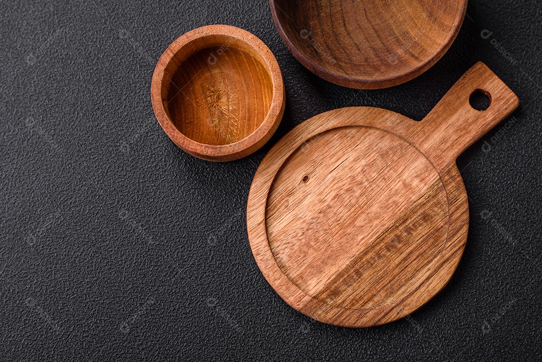 Tábua de corte de madeira de cozinha redonda vazia na cor marrom sobre um fundo de concreto texturizado escuro