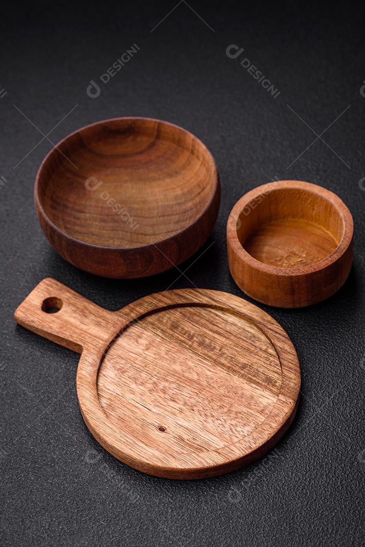 Tábua de corte de madeira de cozinha redonda vazia na cor marrom sobre um fundo de concreto texturizado escuro