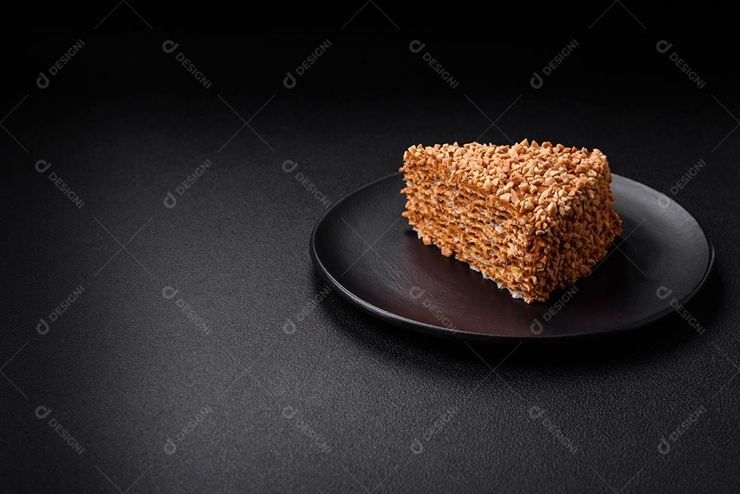 Delicioso bolo de waffle doce com creme e nozes cortados em pedaços sobre um fundo de concreto texturizado