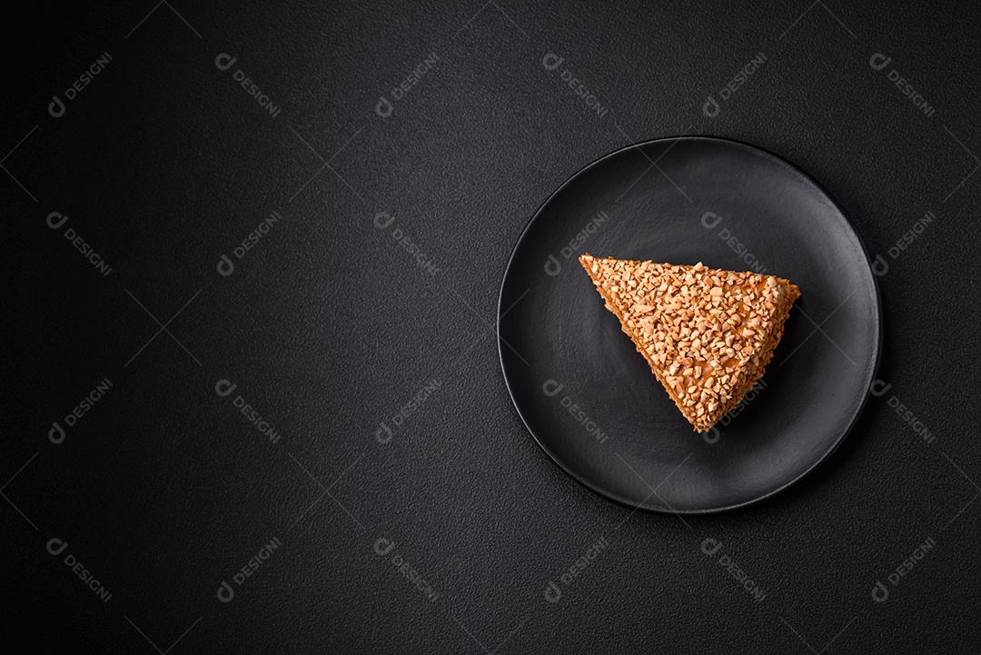 Delicioso bolo de waffle doce com creme e nozes cortados em pedaços sobre um fundo de concreto texturizado