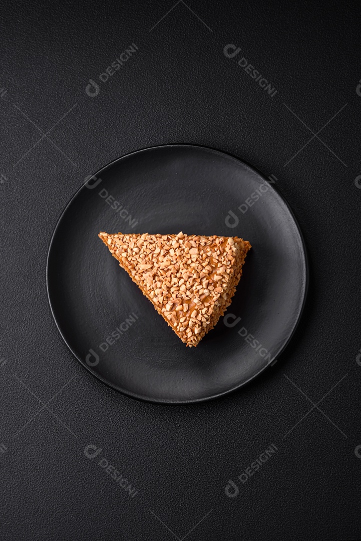 Delicioso bolo de waffle doce com creme e nozes cortados em pedaços sobre um fundo de concreto texturizado