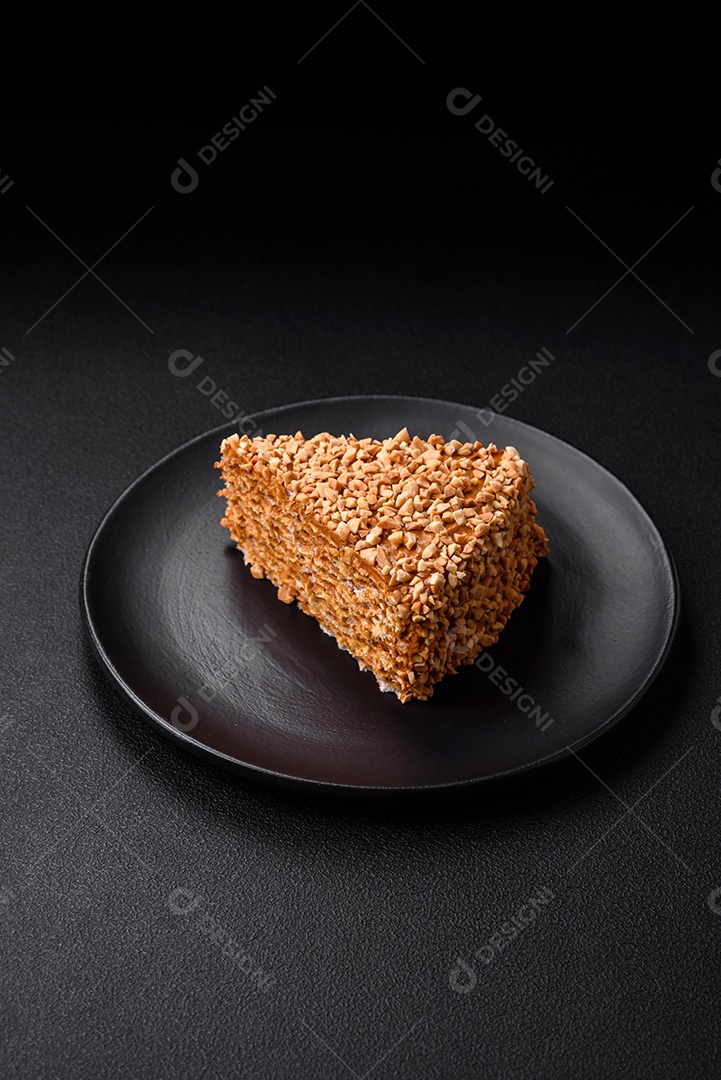 Delicioso bolo de waffle doce com creme e nozes cortados em pedaços sobre um fundo de concreto texturizado