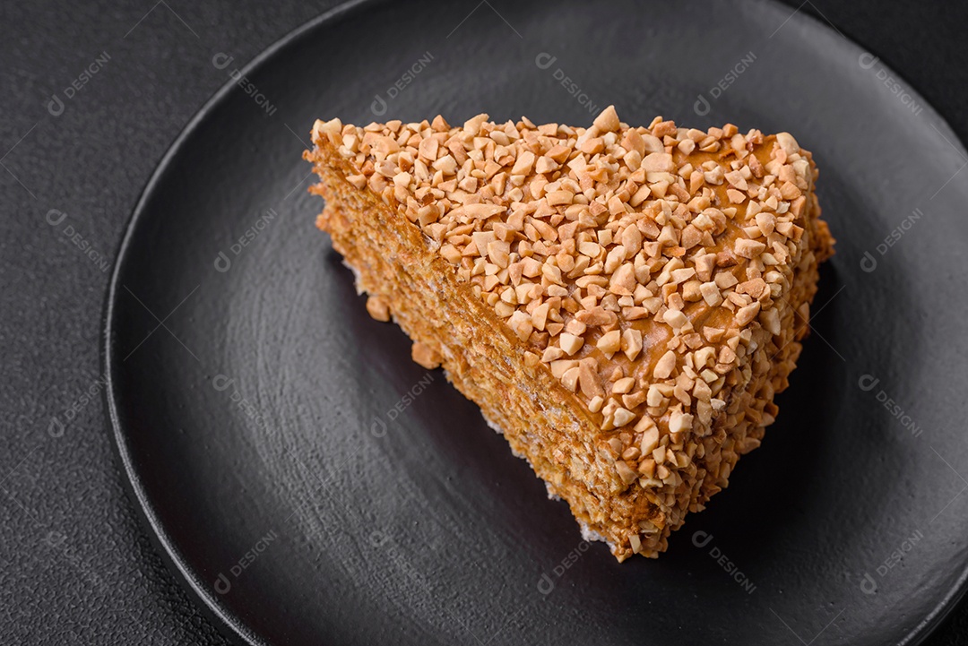 Delicioso bolo de waffle doce com creme e nozes cortados em pedaços sobre um fundo de concreto texturizado