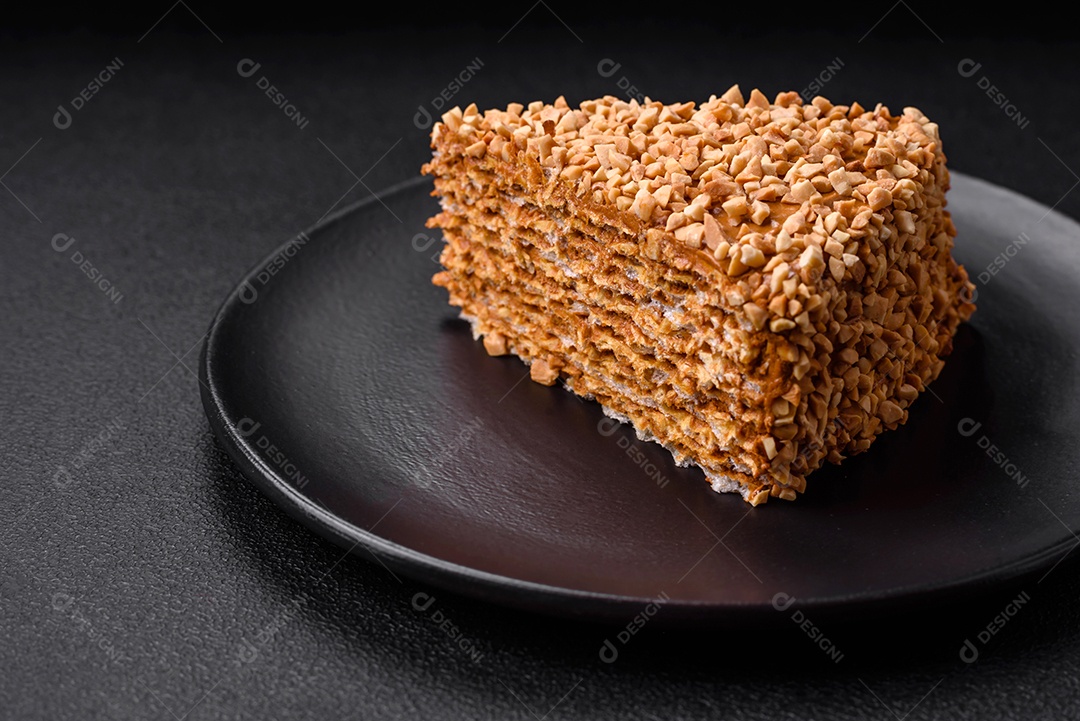 Delicioso bolo de waffle doce com creme e nozes cortados em pedaços sobre um fundo de concreto texturizado