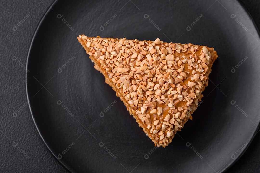 Delicioso bolo de waffle doce com creme e nozes cortados em pedaços sobre um fundo de concreto texturizado