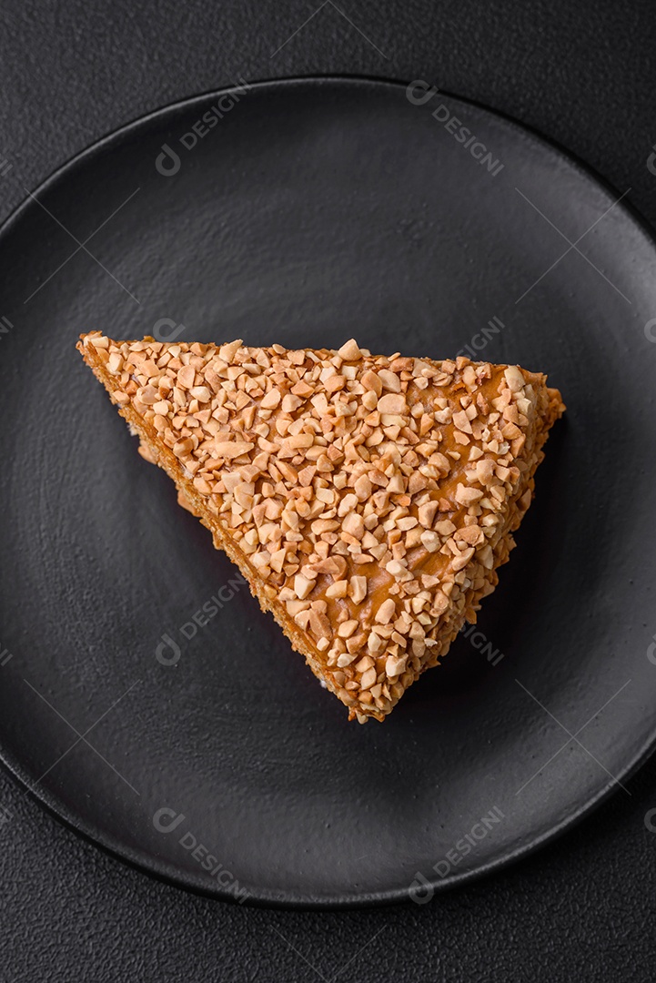 Delicioso bolo de waffle doce com creme e nozes cortados em pedaços sobre um fundo de concreto texturizado