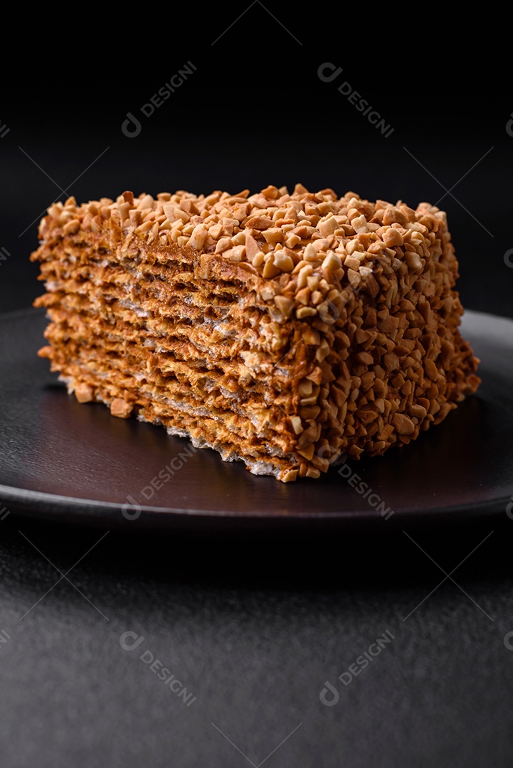 Delicioso bolo de waffle doce com creme e nozes cortados em pedaços sobre um fundo de concreto texturizado