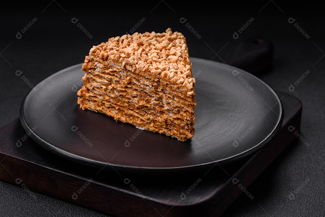 Delicioso bolo de waffle doce com creme e nozes cortados em pedaços sobre um fundo de concreto texturizado