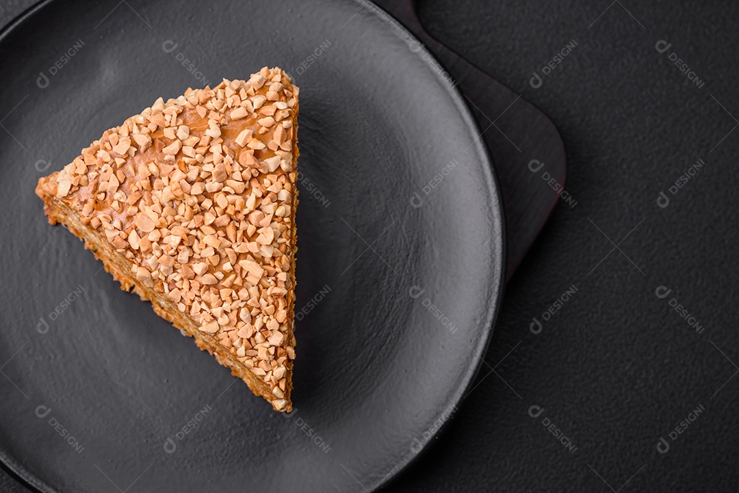 Delicioso bolo de waffle doce com creme e nozes cortados em pedaços sobre um fundo de concreto texturizado