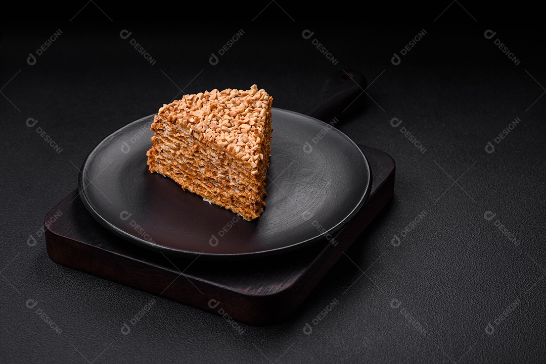 Delicioso bolo de waffle doce com creme e nozes cortados em pedaços sobre um fundo de concreto texturizado