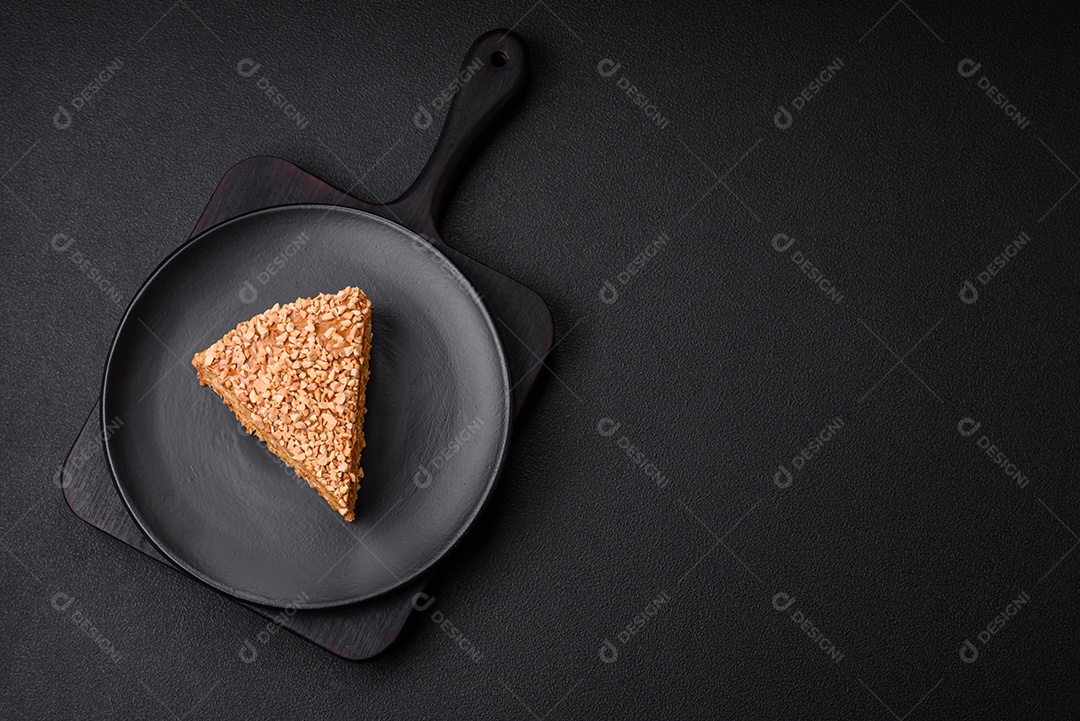 Delicioso bolo de waffle doce com creme e nozes cortados em pedaços sobre um fundo de concreto texturizado
