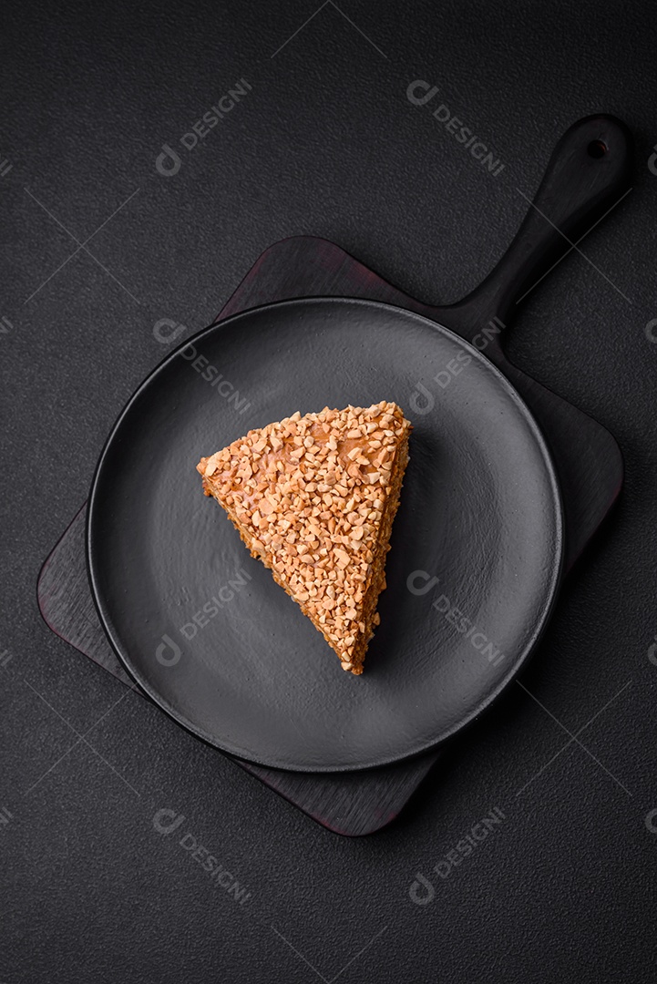 Delicioso bolo de waffle doce com creme e nozes cortados em pedaços sobre um fundo de concreto texturizado