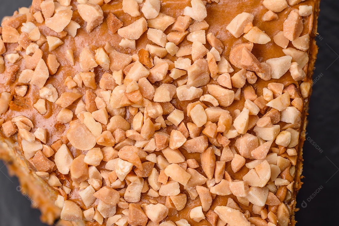 Delicioso bolo de waffle doce com creme e nozes cortados em pedaços sobre um fundo de concreto texturizado