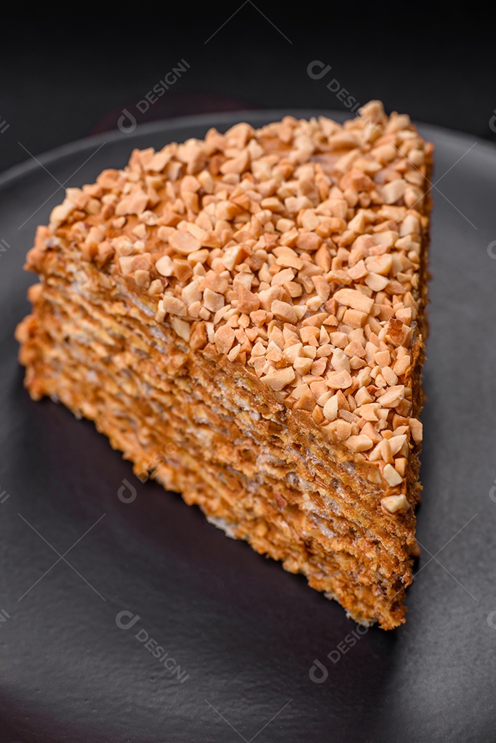 Delicioso bolo de waffle doce com creme e nozes cortados em pedaços sobre um fundo de concreto texturizado