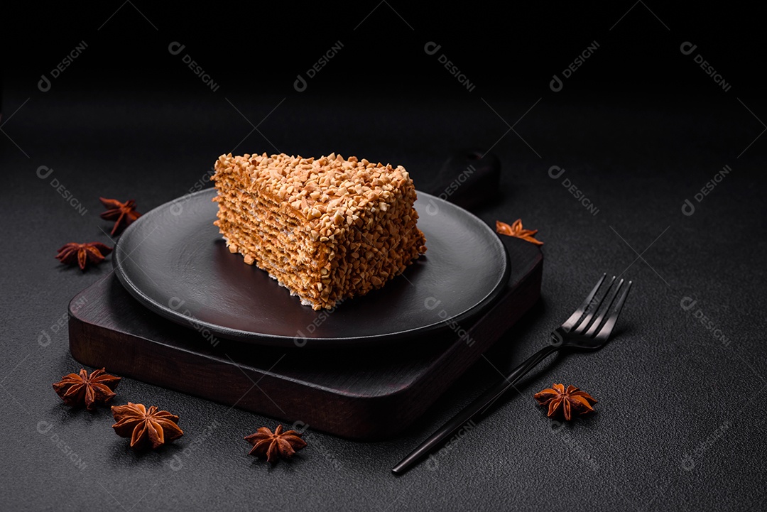 Delicioso bolo de waffle doce com creme e nozes cortados em pedaços sobre um fundo de concreto texturizado