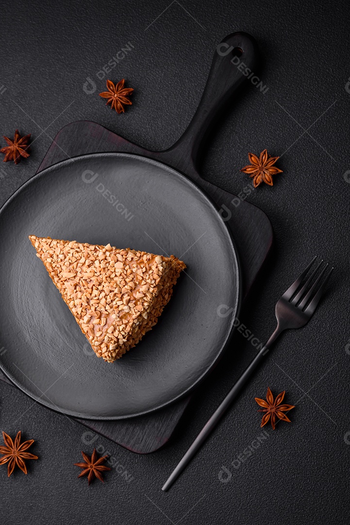 Delicioso bolo de waffle doce com creme e nozes cortados em pedaços sobre um fundo de concreto texturizado