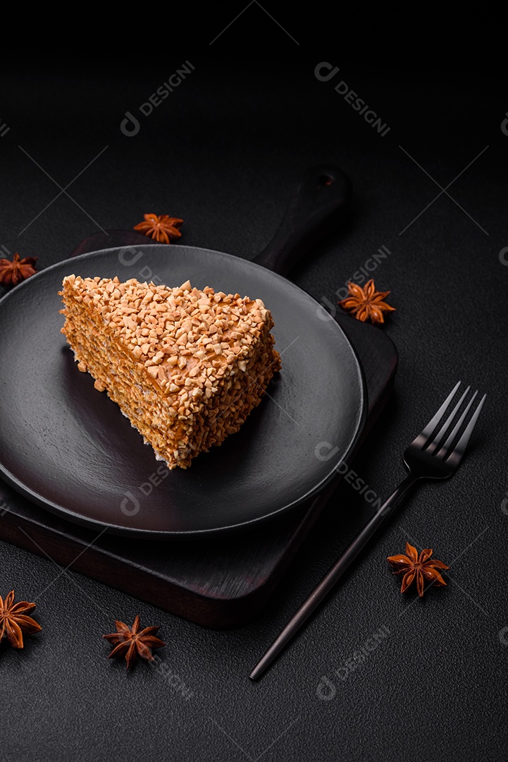 Delicioso bolo de waffle doce com creme e nozes cortados em pedaços sobre um fundo de concreto texturizado