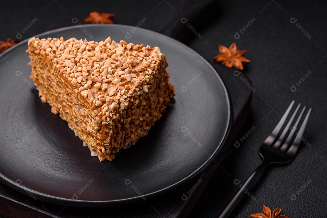 Delicioso bolo de waffle doce com creme e nozes cortados em pedaços sobre um fundo de concreto texturizado