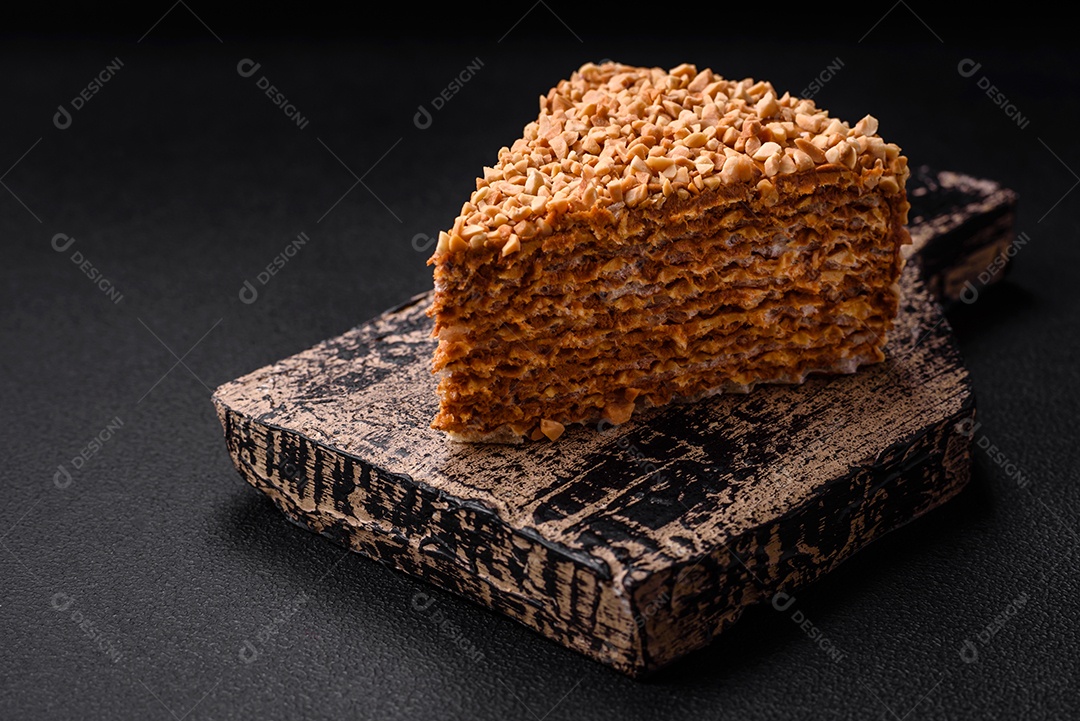 Delicioso bolo de waffle doce com creme e nozes cortados em pedaços sobre um fundo de concreto texturizado