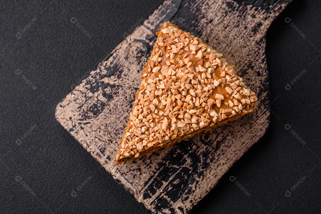 Delicioso bolo de waffle doce com creme e nozes cortados em pedaços sobre um fundo de concreto texturizado