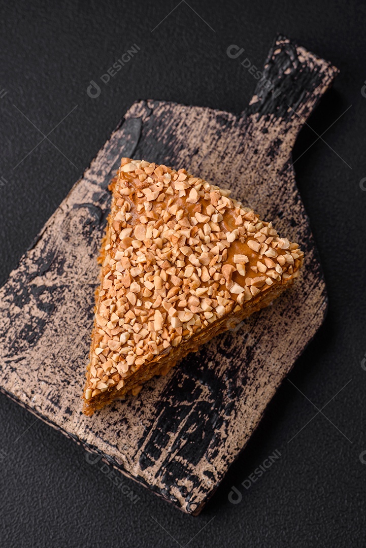 Delicioso bolo de waffle doce com creme e nozes cortados em pedaços sobre um fundo de concreto texturizado