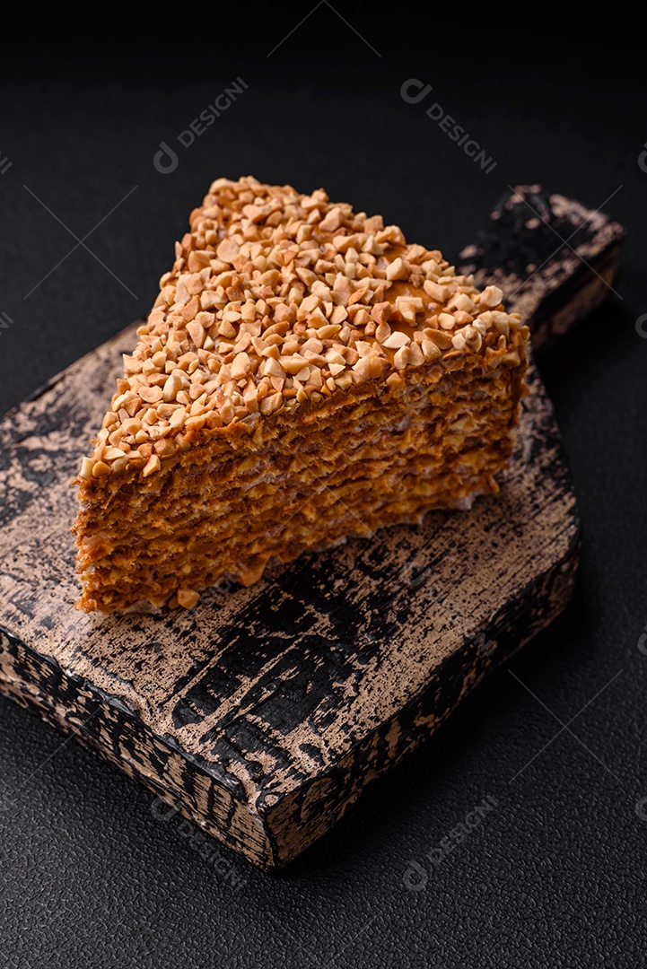 Delicioso bolo de waffle doce com creme e nozes cortados em pedaços sobre um fundo de concreto texturizado