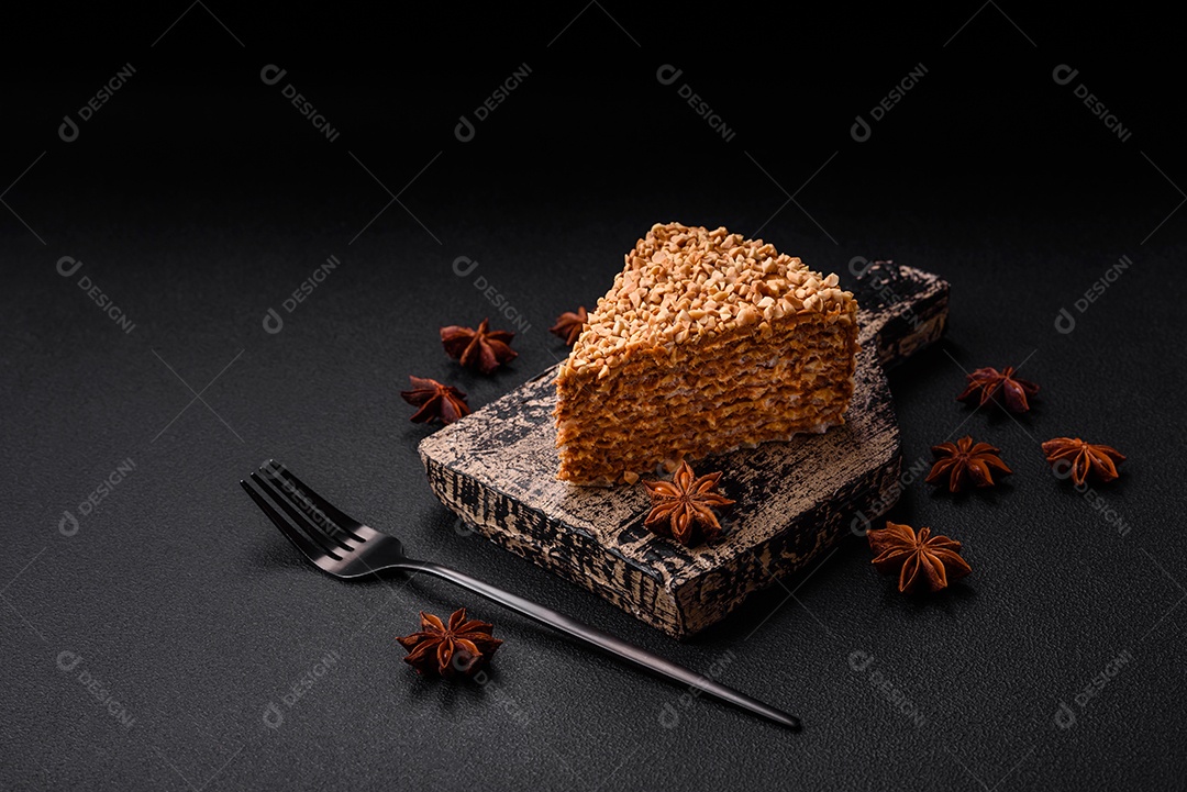 Delicioso bolo de waffle doce com creme e nozes cortados em pedaços sobre um fundo de concreto texturizado