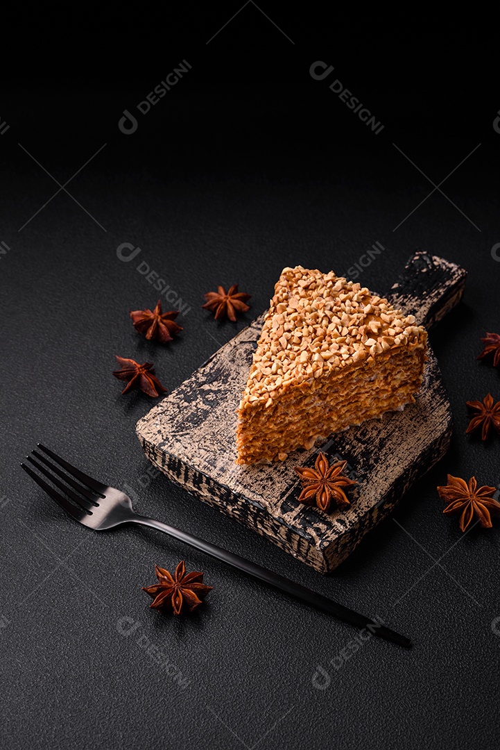 Delicioso bolo de waffle doce com creme e nozes cortados em pedaços sobre um fundo de concreto texturizado