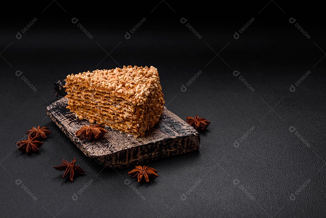 Delicioso bolo de waffle doce com creme e nozes cortados em pedaços sobre um fundo de concreto texturizado