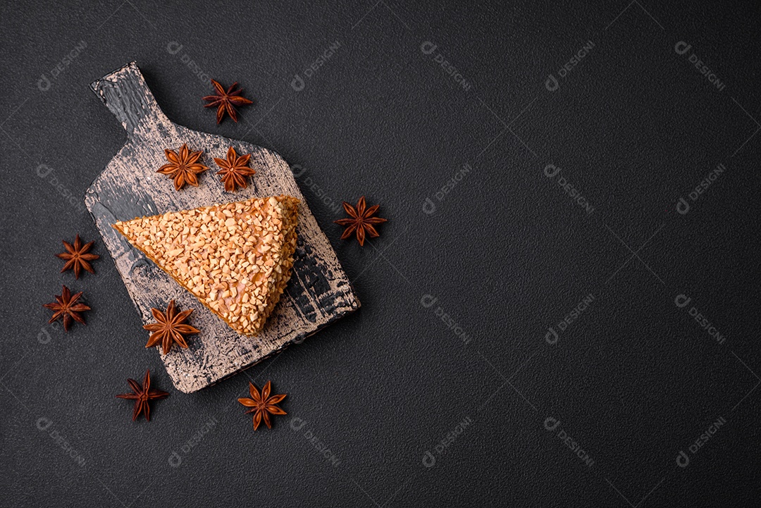 Delicioso bolo de waffle doce com creme e nozes cortados em pedaços sobre um fundo de concreto texturizado