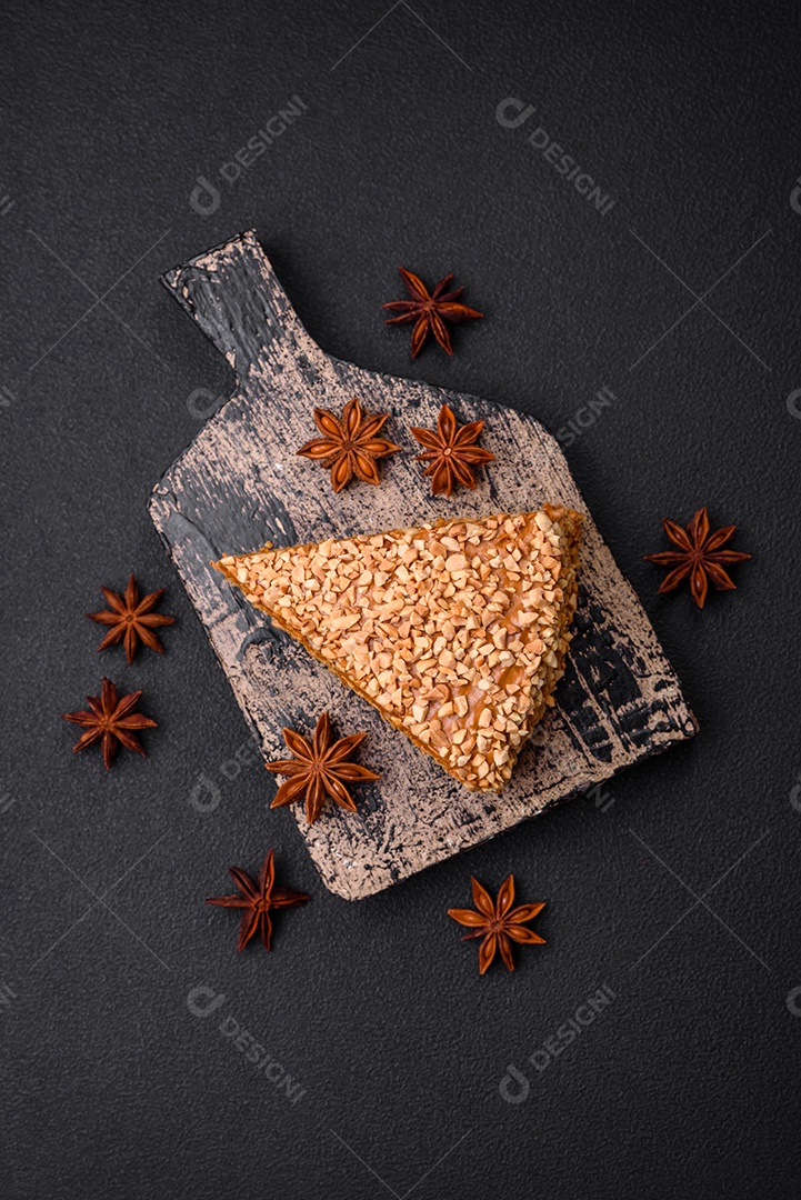 Delicioso bolo de waffle doce com creme e nozes cortados em pedaços sobre um fundo de concreto texturizado