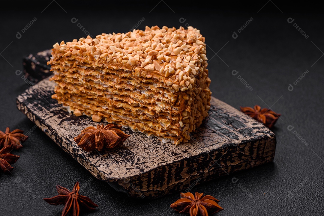 Delicioso bolo de waffle doce com creme e nozes cortados em pedaços sobre um fundo de concreto texturizado