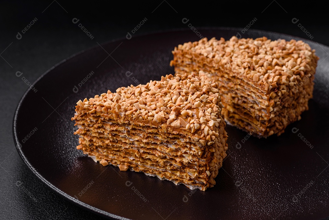 Delicioso bolo de waffle doce com creme e nozes cortados em pedaços sobre um fundo de concreto texturizado