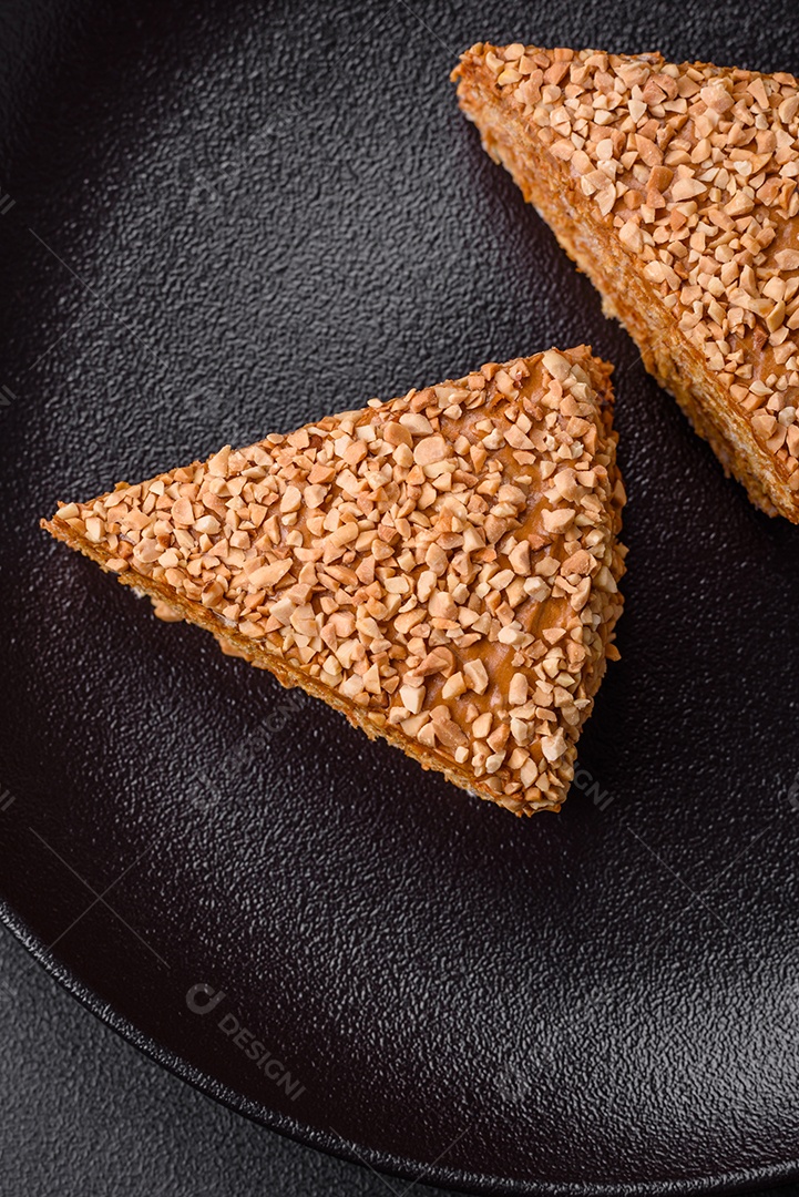 Delicioso bolo de waffle doce com creme e nozes cortados em pedaços sobre um fundo de concreto texturizado