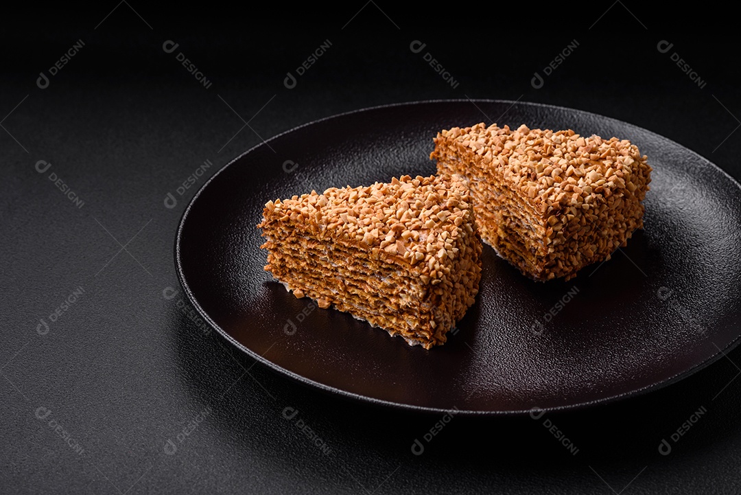 Delicioso bolo de waffle doce com creme e nozes cortados em pedaços sobre um fundo de concreto texturizado