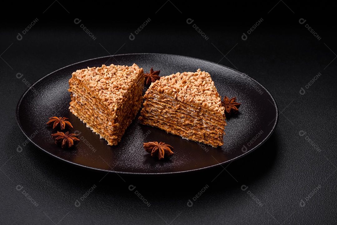 Delicioso bolo de waffle doce com creme e nozes cortados em pedaços sobre um fundo de concreto texturizado