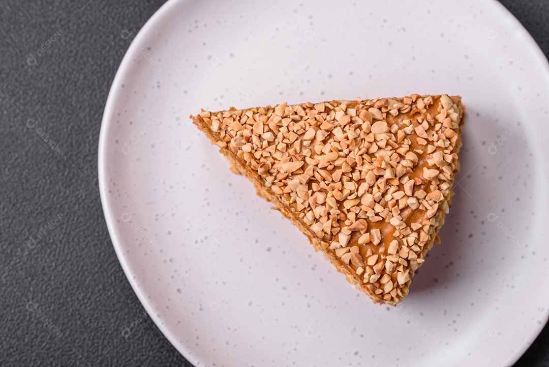 Delicioso bolo de waffle doce com creme e nozes cortados em pedaços sobre um fundo de concreto texturizado