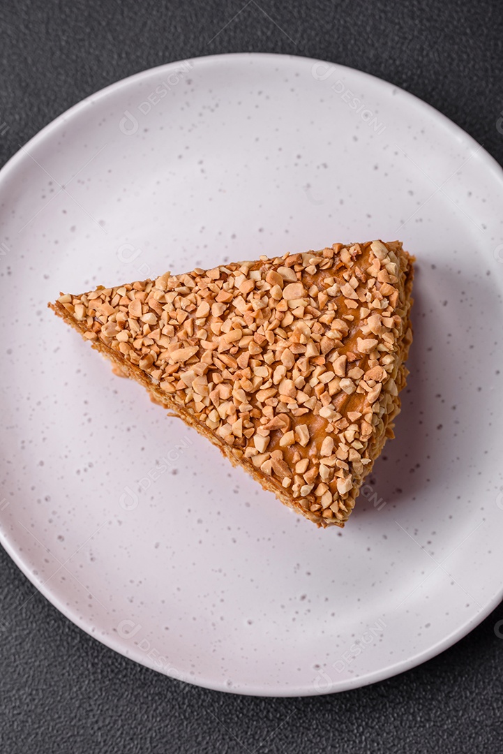 Delicioso bolo de waffle doce com creme e nozes cortados em pedaços sobre um fundo de concreto texturizado