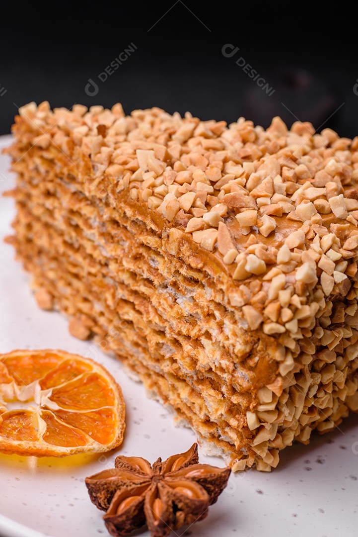 Delicioso bolo de waffle doce com creme e nozes cortados em pedaços sobre um fundo de concreto texturizado