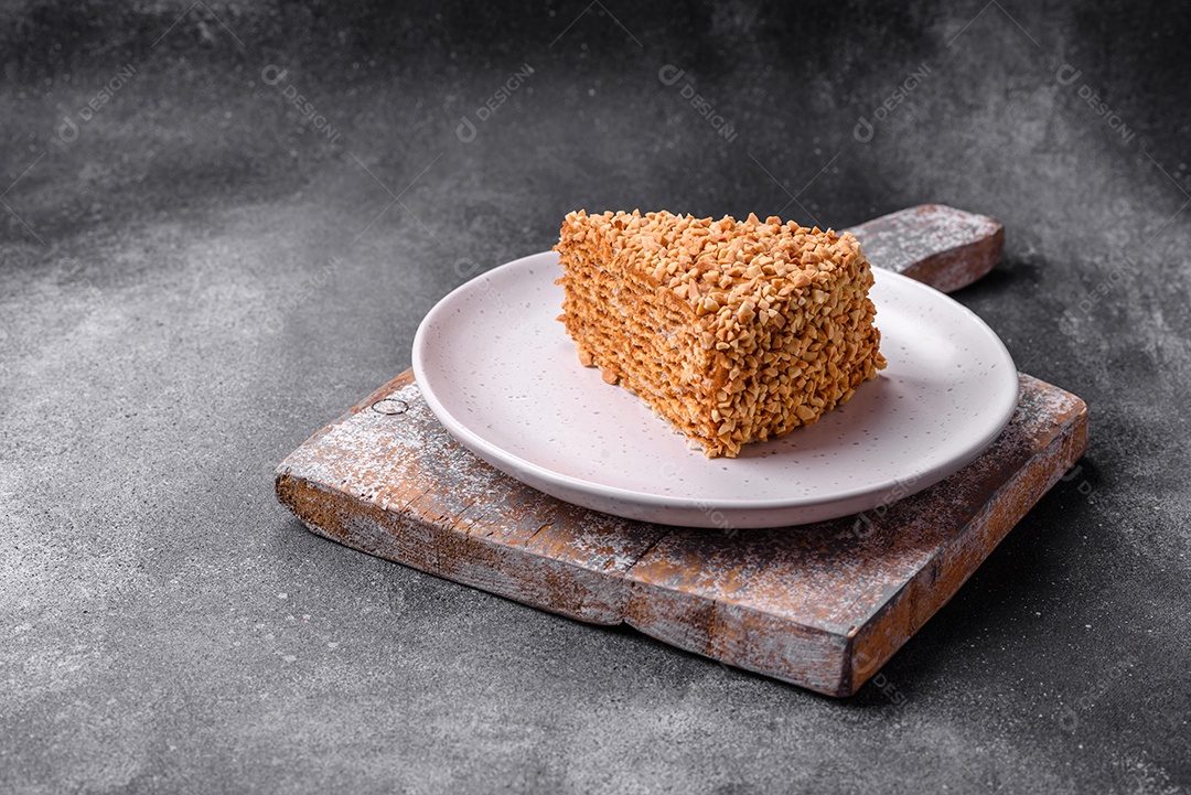 Delicioso bolo de waffle doce com creme e nozes cortados em pedaços sobre um fundo de concreto texturizado