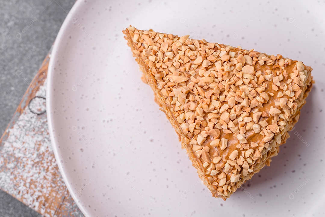 Delicioso bolo de waffle doce com creme e nozes cortados em pedaços sobre um fundo de concreto texturizado